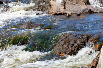 Fragment of stone thresholds in a turbulent stream of water of a mountain river.