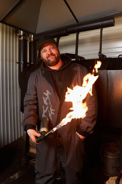 Smiling chef standing with blow torch in hand