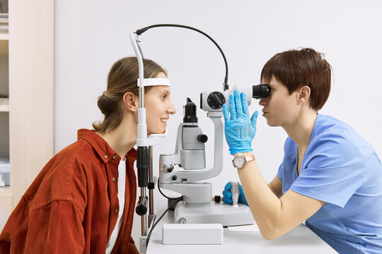 Ophthalmologist conducting vision diagnostics test with patient at clinic