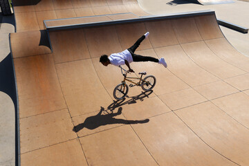 Man practicing stunts on BMX bike at skatepark