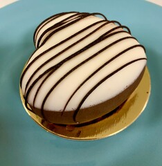 Coffee cream dessert, heart shaped panna cotta on a plate on a blue background
