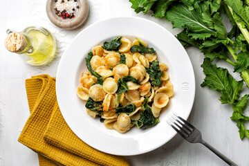 Top view of pasta recchiette con le cime di rapa e le acciughe popular in Southern Italy dish, typical of Apulia. Made with anchovy, bread crumbs and rapini, or broccoli rabe or turnip greens.