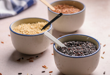 three bowls with different types of rice. Red, black and brown