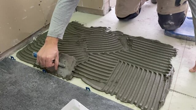 4k video footage of laying a large wide-format tile for mortar.