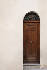Fototapeta na wymiar Minimalist shot of a small wooden door against a yellow wall