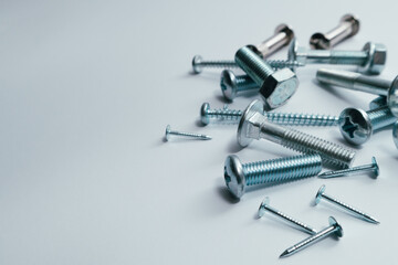 Set of bolts, screws, nails on a white background. Construction abstraction. Industrial background. Screws and bolts macro photo, screw background, steel screw, bolt macro.