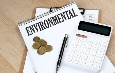 ENVIRONMENTAL text on a notebook with chart and calculator and coins, business concept