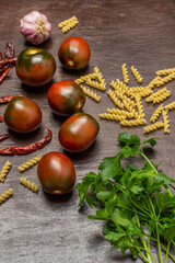 Parsley sprigs, tomatoes and pasta. Top view.