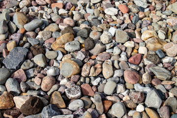 High-quality photo of a textured surface with large pebbles and small stones  It can be used as a background image or texture for design projects related to nature, beach, or outdoors.