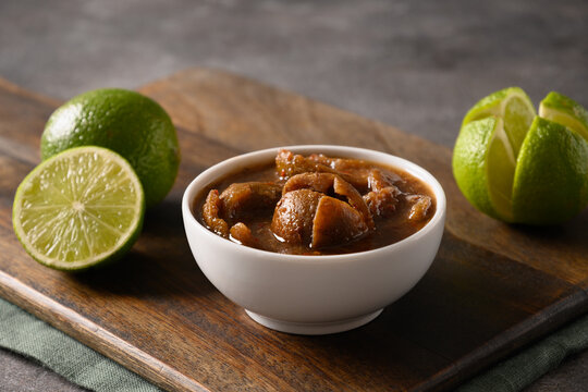 Traditional Sri Lankan Lime Pickle of lime, salt, chilli, pepper on brown background. Close up.