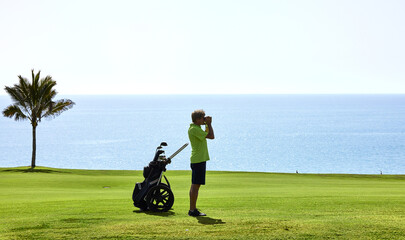 Golfer on a golf course, ready to tee off. Golfer with golf club hitting the ball for the perfect...