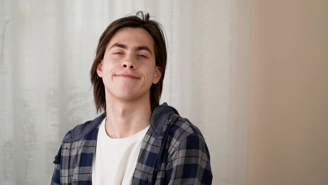 The spectrum of emotions. Own space, closeness, teenage problems - unwillingness to communicate. handsome young guy smiles, doubts, gets angry, hides his face in a hood