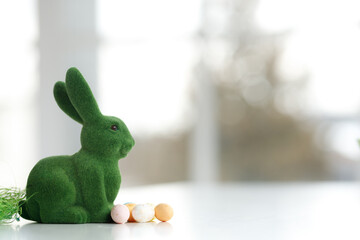 Easter bunny rabbit statuette. Close up, copy space. Easter eggs. Chicken eggs, twigs with green...