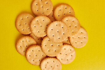 A pile of round cookies on a yellow background. A tasty and sweet snack.