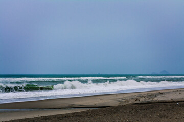 Angry ocean waves breaking on a empty sand beach. Kohe o Awa Beach, Pacific Coast, North Island, New Zealand