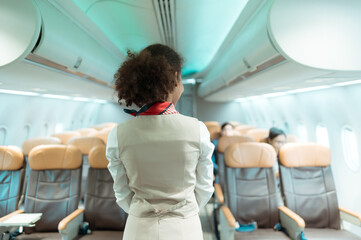 Flight attendants show how to use safety devices and recommend emergency exits.