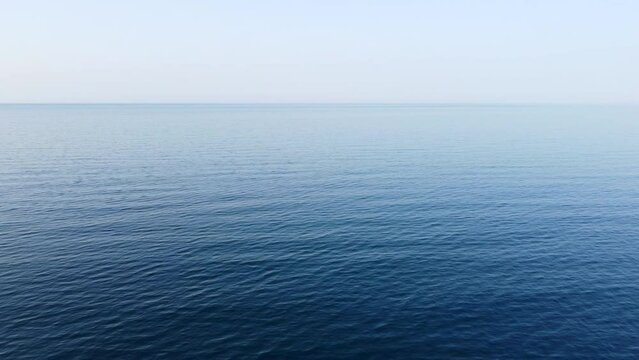 Slow aerial over the open ocean, drone view over the deep blue sea