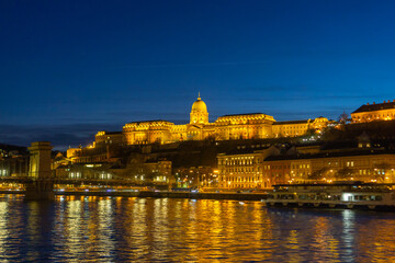 Fototapeta na wymiar The Budapest Royal Palace at night, with the Danube in the foreground
