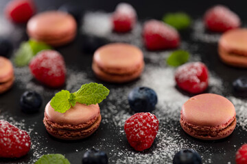 macaroons of different colors on a black background