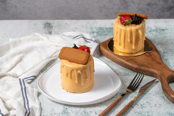 Caramel and biscuit cake. Patisserie products. Portion liquid caramel cake on a gray background