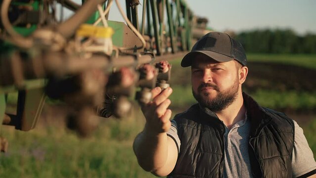A mechanic is repairing a tractor used in agriculture. Agricultural machinery repair, open hood, modern engine, tractor maintenance. Repair agricultural technology at sunset.