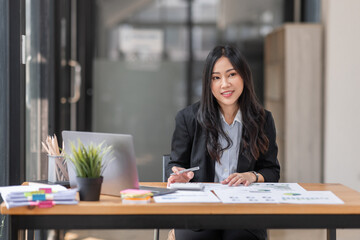 Business Asian woman working at office with documents on her desk, doing planning analyzing the financial report, business plan investment, finance analysis concept
