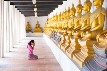 Asian woman to pay respect to Buddha statue in thailand.