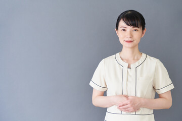 手で案内するエステ・美容クリニックの女性