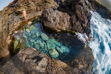 Woman in bikini enjoying the natural pools on the coast of Tenerife in the Canary Islands