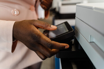 African american woman in suit standing by copy machine at office