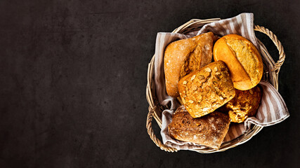 Basket with appetizing rolls on a black background. View from above