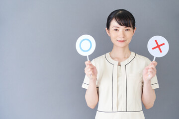 マルバツの棒を持つエステ・美容クリニックの女性