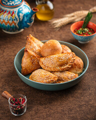 Portion of assorted uzbek baked samsa pies with sesame