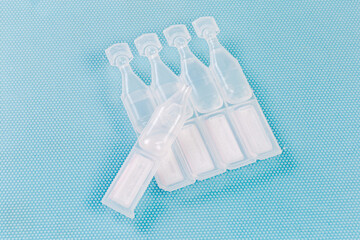 Eye drops in small disposable plastic ampoules, one open ampoule
