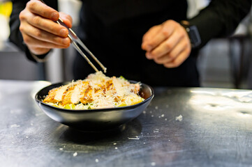 Chef cooking Caesar salad on restaurant kitchen