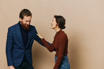 Obraz premium Man and woman couple in a relationship smile and interaction on a beige background in a real relationship between people