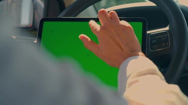 driver sitting in the car scrolling isolated green screen using digital tablet summer road trip