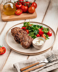 Portion of russian beef cutlets with sauce and salad