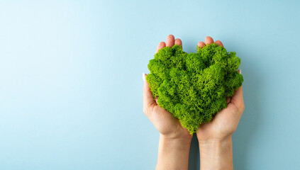 World earth day concept with green plant heart on blue background, - obrazy, fototapety, plakaty