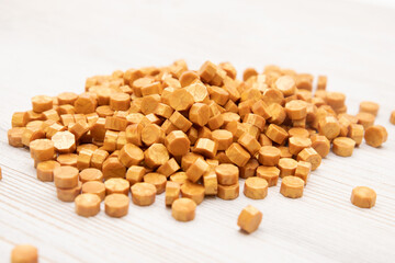 heap of yellow golden sealing wax granules beads on wooden table. front view