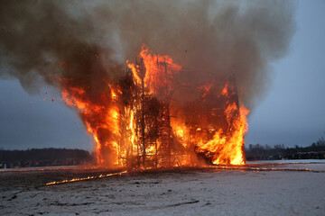 Fire. Russian Maslenitsa. Celebration of Maslenitsa 2023. Traditional national folk holiday in Nikola-Lenivets, Kaluga region, Russia. Russian landmark. Burning wooden castle © Sergey