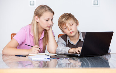 Family Life, Computer Studies. A teenage girl giving her younger brother some academic advice with his homework. From a series of related images.