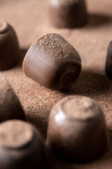 Chocolate bonbons and cocoa powder background. Close up