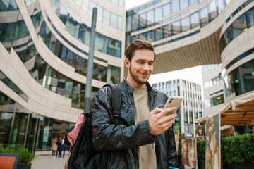 Young man using mobile phone while standing outdoors