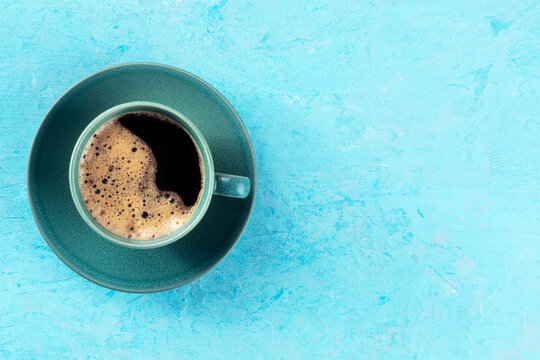 Coffee cup, shot from above on a blue background with copy space, espresso drink