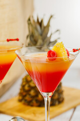 Bikini martini cocktail in martini glass garnished with cherries and pineapple. Martini alcoholic cocktail or non-alcoholic mocktail. Martinis.