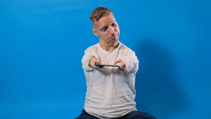 a man with disabilities is playing a game on a smartphone on an isolated background.