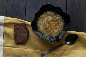 Appetizing traditional Russian dish Shchi - sour cabbage soup served in bowl, on a wooden table.