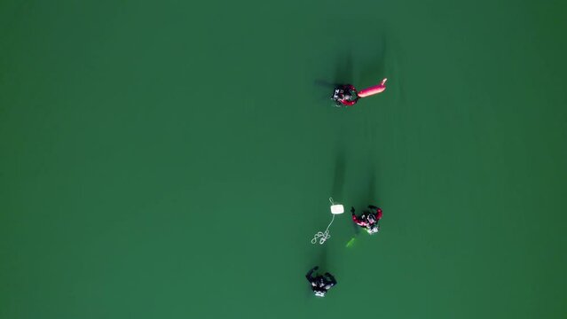Low aerial shot overhead a group of divers training in the Lac du Cr&egrave;s, France