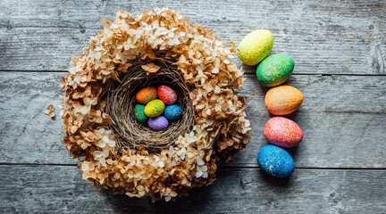 Easter eggs in a nest on a wooden background. High quality photo. nest of dried flowers. place for teekst, banner